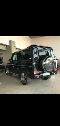 This phone live wallpaper depicts a black SUV parked in a car showroom