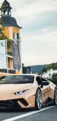 This live wallpaper features a sleek beige sports car parked on the side of a winding road against a pastel-toned image of a baroque-style building for a luxurious look