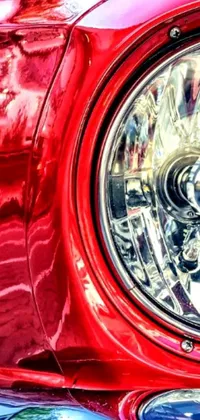 This live wallpaper showcases a striking close-up of a red car headlight that captures the energy of lowrider culture