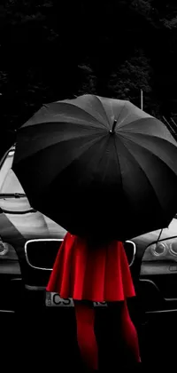 This iPhone live wallpaper showcases an art photograph with a person holding up an umbrella in front of a car