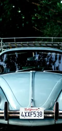 This live wallpaper features a blue vintage Volkswagen Beetle parked on the roadside, with a roof rack, and a close-up of the car window