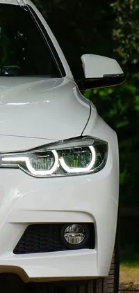 This phone live wallpaper features a stunning white BMW car, parked at the side of a road