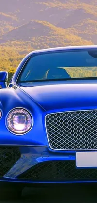 This captivating live wallpaper showcases a striking blue car cruising down a scenic mountain road