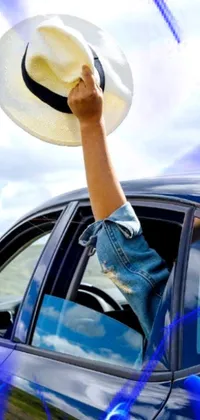 Enhance your phone screen with this stunning live wallpaper featuring a man wearing a hat riding as a passenger on a car