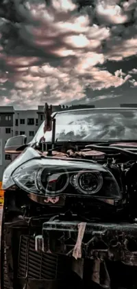 This phone live wallpaper features an auto-destructive art style depicting a mangled BMW car on the side of the road