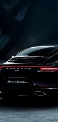 This live phone wallpaper showcases a black Porsche parked in a parking lot with illuminated rear lights