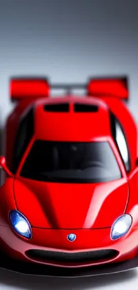 This phone live wallpaper features a highly detailed 3D render of a vintage toy car in red, sitting atop a table