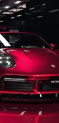 This powerful <a href="/">live wallpaper</a> showcases a glossy red sports car, a Porsche 911, parked inside a spacious garage