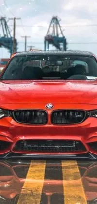 This live wallpaper showcases a stunning red BMW car parked on the side of the road