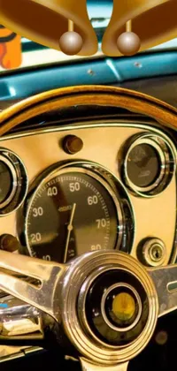 This live wallpaper depicts a close-up of a vintage sports car's steering wheel, featuring a brown and cyan blue color scheme