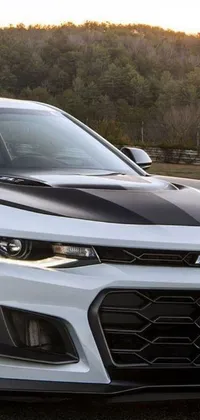 This phone live wallpaper features a white Chevrolet Camaro parked in a secluded parking lot