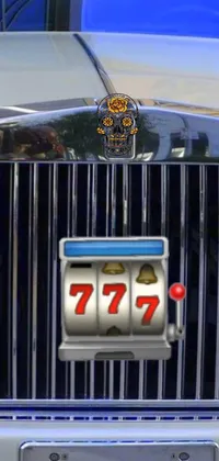 This phone live wallpaper features a beautiful close up shot of a modern number plate on a car, set against a backdrop of colorful fruit machines displaying the lucky 7-7-7-7 combination