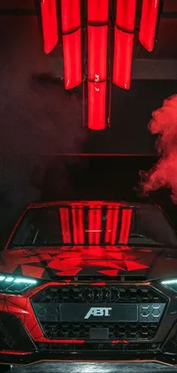 This phone live wallpaper features a vibrant image of a red car emitting smoke captured in a photograph