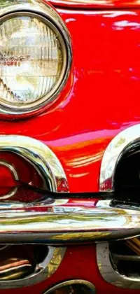 This live wallpaper showcases a stunning close-up of a vintage red car's front end with classic 50s style chrome plating and bright lights