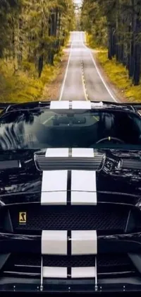 This dynamic phone live wallpaper features a stunning black sports car cruising along a winding road