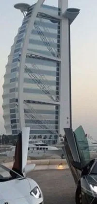 This live wallpaper showcases two luxurious Lamborghinis parked in front of a tall building in Dubai, surrounded by the city&#39;s iconic skyline