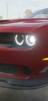 This phone live wallpaper showcases a captivating glimpse of a red muscle car on a street racing track, with smoke emitting from it creating an adrenaline-pumping environment