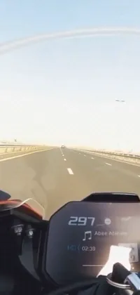 This thrilling phone live wallpaper features an action-packed scene of a motorcycle rider cruising down a busy highway