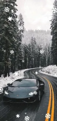 This phone live wallpaper features a black sports car speeding down a snowy road lined with mountains