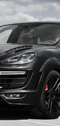 Enjoy the sleek look of a black Porsche Cayenne parked in a spacious lot with this live wallpaper