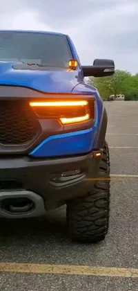 This phone live wallpaper features a striking blue truck parked in a large parking lot, complete with detailed horns and indicator lights