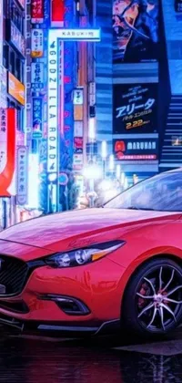 This phone live wallpaper showcases a stunning red Mazda parked on a bustling city street in Tokyo, surrounded by vibrant Japanese neon signs and crowds of people