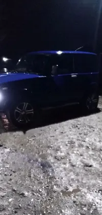 Get ready to add some thrill to your phone with this stunning live wallpaper that showcases a lone blue car in a dark parking lot, ready for off-roading