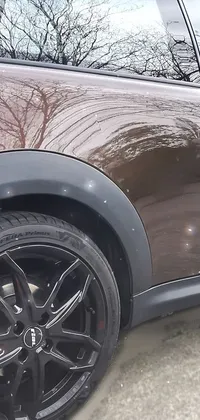 This live wallpaper features a brown mini cooper parked in a lot