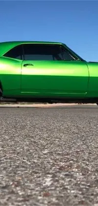 Get your motor running with this live wallpaper featuring a green muscle car parked on the side of a winding road