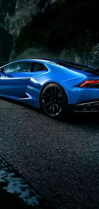 This stunning live wallpaper features a sleek blue sports car parked alongside a winding mountain road