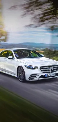 Are you looking for a luxurious phone live wallpaper? Check out our white Mercedes S-Class live wallpaper! This wallpaper features a high-quality digital rendering of a vehicle driving on a road