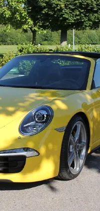 Experience the thrill of a yellow Porsche 911 convertible with this live phone wallpaper