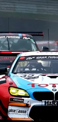 This phone live wallpaper captures the thrill of sports car racing with a group of powerful vehicles speeding down a race track