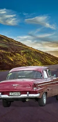 The perfect wallpaper for vintage car enthusiasts! This phone live wallpaper features a breathtaking photorealistic image of a red classic car parked on a Cuban street in the golden hour