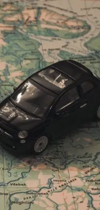 This phone live wallpaper features a black toy car sitting atop a map of Europe, a perfect combination for car enthusiasts