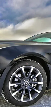 Looking for a stunning live wallpaper for your phone? Check out this amazing design featuring a black mustang parked on the side of the road