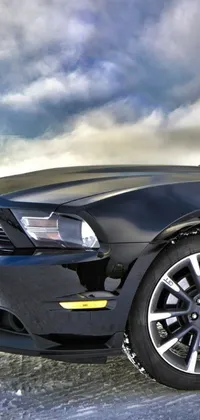 This live wallpaper features a photorealistic black sports car parked in an empty parking lot