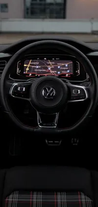 This stunning live phone wallpaper showcases a sleek steering wheel in striking Vanta black with pops of vibrant red accents