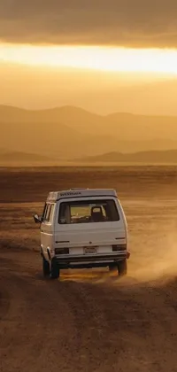 Elevate your phone's wallpaper with this scenic live wallpaper of a white van traversing a dirt road in the American West