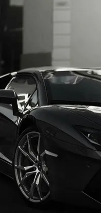 This phone live wallpaper is a photorealistic image of a black sports car parked in front of a building