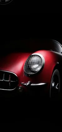 This mobile wallpaper depicts a captivating vintage red sports car - a Corvette C2 1969 - amidst a dark background, featuring HD photorealistic artwork created in ultra HD resolution