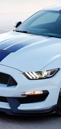 This live wallpaper showcases a sleek white and blue Mustang parked in a parking lot captured in a medium closeup shot