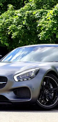 This stunning live wallpaper features a silver sports car parked on the side of the road