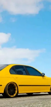 Elevate your phone's appearance with a picturesque live wallpaper featuring a bright yellow car parked on the side of a stunning road