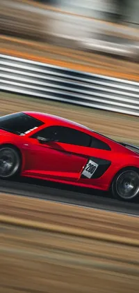 This thrilling phone wallpaper showcases a red sports car racing along a track, depicted with exceptional clarity thanks to a Canon EOS R6 camera