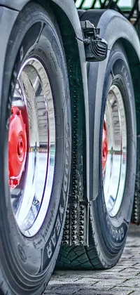 This phone live wallpaper features a digital rendering of two truck tires in motion, captured in a rear-shot of the vehicle