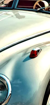This live wallpaper features a close-up of a silver, red, and white scarab car parked on the side of the road