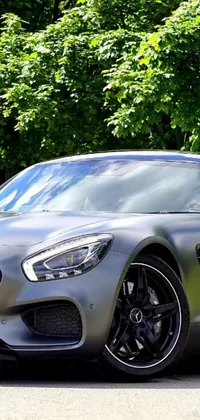 This live wallpaper features a silver sports car parked on the side of a road