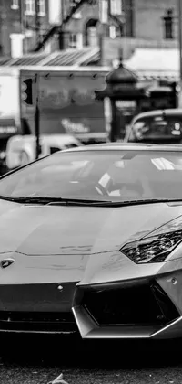 This dynamic phone live wallpaper features a captivating black and white photograph of a Lamborghini-style sports car in stunning detail