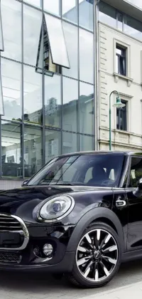 This black mini cooper live wallpaper features an iconic car parked in front of a city building